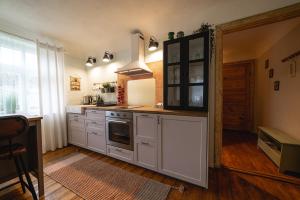 库尔迪加Pils Parka Apartamenti的厨房配有白色橱柜和炉灶。