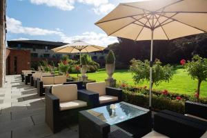科克马里伯勒温泉酒店的一个带桌椅和遮阳伞的庭院