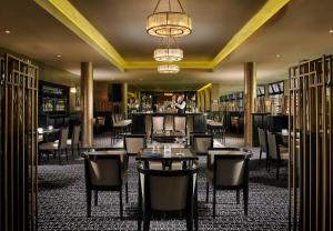 科克马里伯勒温泉酒店的一间带桌椅的餐厅和一间酒吧