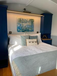 牛津The Bibury - Westwell Downs Shepherd Huts的一间卧室配有一张白色大床和蓝色橱柜