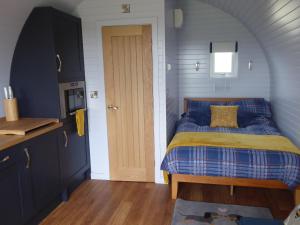 切斯特Honeypot Hideaways Luxury Glamping - Exclusively for Adults的一间卧室配有一张蓝色和黄色的被子