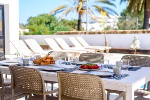 圣何塞德萨塔莱阿Villa Sa Marinada | 100m de Mar的庭院里一张带食物的白色桌子