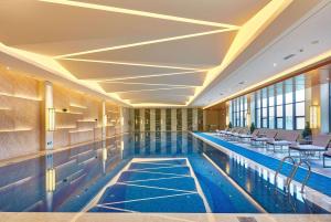 荆州荆州南国温德姆酒店的大楼内一个带桌椅的游泳池