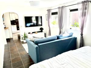 特鲁萨Casa Tureholm - ett mysigt hus i idylliska Trosa的客厅配有蓝色的沙发和床。