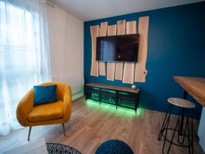 沙马列尔HESPERIE Thermes的客厅配有椅子和蓝色墙壁上的电视