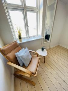 腓特烈港aday - Frederikshavn City Center - Room 5的一张椅子,放在一个镜子和一张桌子的房间