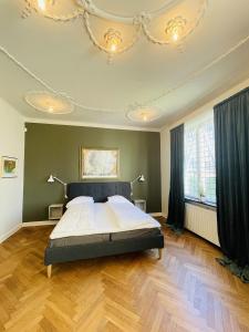 腓特烈港aday - Frederikshavn City Center - Luxurious room的一间卧室配有一张床和一个吊灯