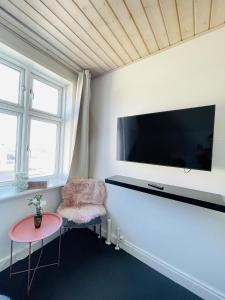 腓特烈港aday - Frederikshavn City Center - Single room的客厅配有壁挂式大屏幕平面电视