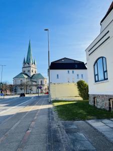 腓特烈港aday - Frederikshavn City Center - Single room的街道中间有陡峭的教堂