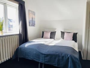 腓特烈港aday - Frederikshavn City Center - Room 2的一间卧室配有一张大床,铺有粉色和蓝色的床单。