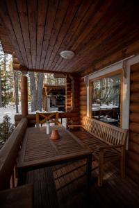 AlajõeOkka Holiday Home的小屋门廊上的木桌和长凳