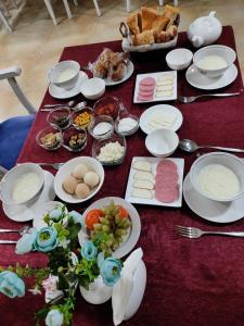 布哈拉Alliance hotel bukhara的餐桌上放有盘子和碗的食物