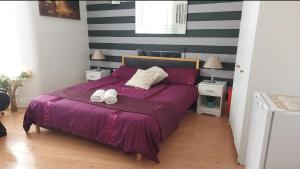 利物浦Spacious Double Room in Anfield的一间卧室配有一张紫色床和两条毛巾