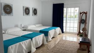贝尼多姆Villa Mis 5 Amores con piscina的一间卧室设有两张床和大窗户
