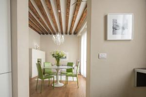 威尼斯Santa Fosca Design Apartment R&R的一间带桌子和绿色椅子的用餐室