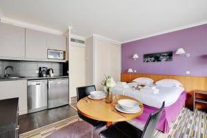 伊西莱穆利诺CMG - Cosy & charmant appartement Paris的厨房以及带桌子和床的客厅。