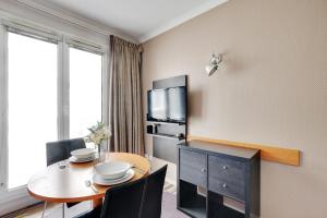 伊西莱穆利诺CMG - Cosy & charmant appartement Paris的酒店客房设有桌子和电视。