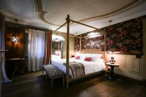 BossolascoLa Piazzetta degli Artisti - Boutique B&B的一间卧室设有天蓬床和壁画