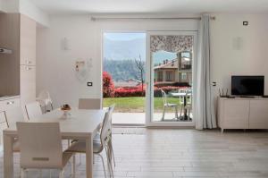 伦诺Appartamento Zerboni C1的厨房以及带桌子和电视的用餐室。