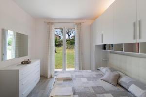 伦诺Appartamento Zerboni C1的白色的卧室设有床和窗户