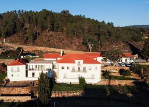 小佩德罗冈Quinta da Rocha 1875的一座大型白色房屋,设有红色屋顶