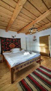 BrebCăsuța din Gradina的一张位于带木制天花板的客房内的大床