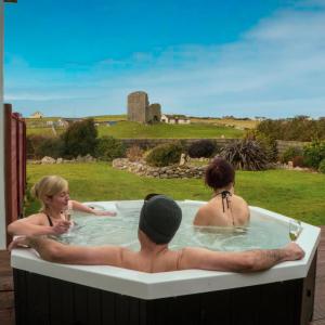 杜林Luxury Lodges in Doolin Village with Hot Tubs的一群人在带酒杯的热水浴缸中