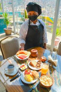 拉巴斯Hotel Las Brisas Centro的坐在餐桌上吃着早餐的面具男人