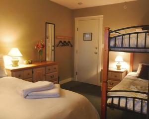 纳奈莫锦龟宾馆的一间卧室配有一张床和一张带镜子的双层床