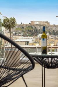 雅典Arcade Hotel Athens的椅子上坐着一瓶葡萄酒