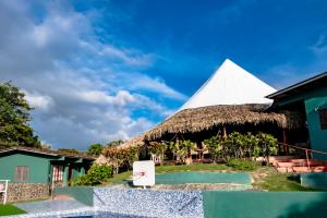 La PintadaLa Pintada Inn的拥有稻草屋顶和白色金字塔的度假胜地