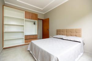 伊瓜苏Apartamento região central de foz do Iguaçu的卧室配有白色的大床和架子