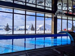 古多里GVC 3-room 2-level apt New Gudauri的享有雪覆盖山脉景致的游泳池