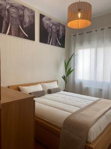 马德里Las Meninas de Cavero的一间卧室,配有一张带两张大象海报的床