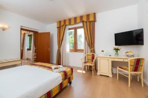 扎托尔Villa Królewiec - 1,5km od Energylandii的酒店客房配有一张床、一张书桌和一台电视。