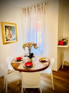 加尔达湖滨Mutti Stay apartments的餐桌、椅子和鲜花