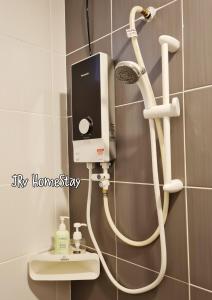马六甲JRv HotelStyle HomeStay Melaka的带淋浴的浴室,配有白色软管