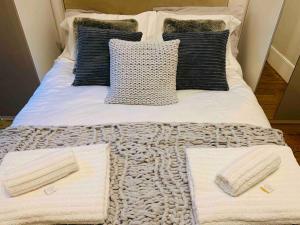 伦敦Luxury Fulham Flat with 5* touches nr River Thames的一张带白色毯子和枕头的床