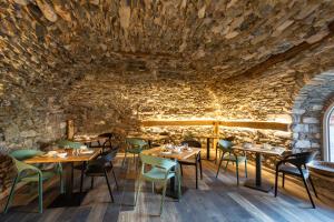 穆索Agriturismo Il Medeghino的石墙内带桌椅的餐厅