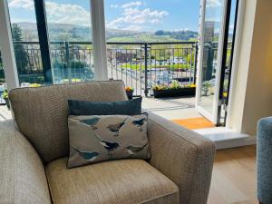 巴洛赫Riverside View Penthouse in Balloch, Loch Lomond的客厅配有带枕头和海豚的椅子
