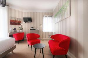 拉波勒贝斯特韦斯特布列塔尼拉博勒中心酒店的一间设有红色椅子、桌子和床的房间