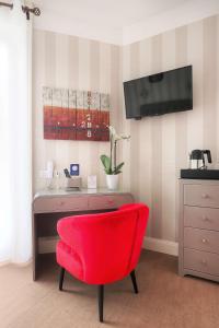 拉波勒贝斯特韦斯特布列塔尼拉博勒中心酒店的一张带红色椅子的桌子和墙上的电视