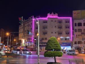 伊尔比德萨拉皇冠酒店 的建筑的侧面有粉红色的灯