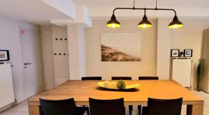 克诺克－海斯特Familie appartement hartje Knokke met optie parking的一间带木桌和椅子的用餐室