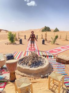 梅尔祖卡Sahara wellness camp的站在沙漠中间的人