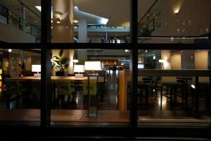 名古屋CYPRESS HOTEL Nagoya-eki Mae的从带桌椅的餐厅的窗户欣赏美景