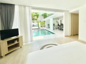 塞米亚克Alami Luxury Villa的一间卧室设有一张床和一台电视,还有一个游泳池