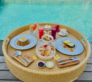 塞米亚克Alami Luxury Villa的桌边的桌边,桌边摆着早餐食品和饮料