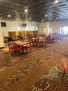 格里利Quality Inn and Conference Center Greeley Downtown的用餐室配有木桌和红色椅子