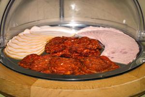 久洛Corso Boutique Hotel的一种慢煮器,有不同种类的肉和奶酪